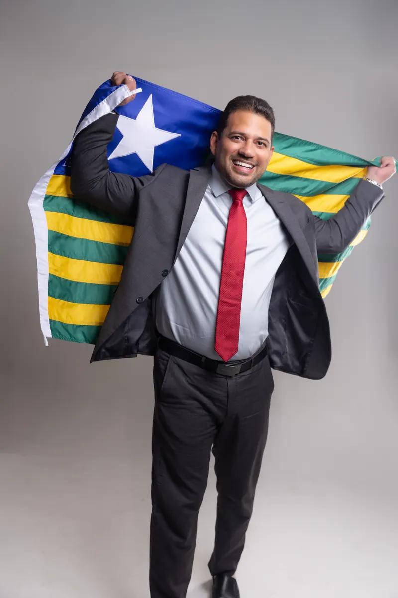 Dr. Thales Coelho abrindo a bandeira do Piauí atrás dos ombros